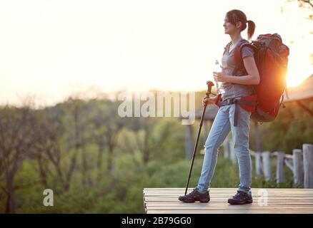 jeune femme profitant du coucher du soleil après la randonnée dans la nature. vie saine, positif, concept de la nature Banque D'Images