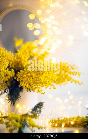 Bouquet de fleurs mimosa jaunes, décoration intérieure or vif et spots lumineux Banque D'Images