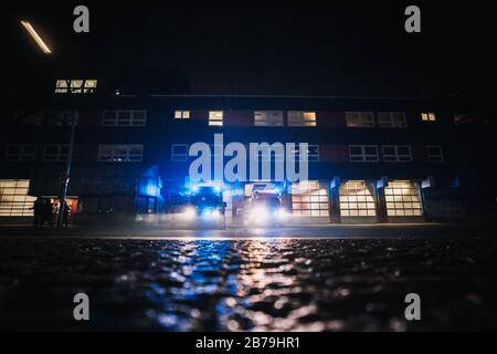 Caserne de pompiers la nuit avec des pompiers qui répondent à un appel d'urgence et partent Banque D'Images