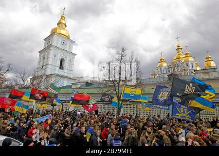 Foule de personnes avec drapeaux pendant le mois de mars.Des Milliers de militaires et de volontaires ukrainiens ont participé à la marche des patriotes marquant la Journée des volontaires honorant les soldats qui ont rejoint l'armée ukrainienne pendant un conflit militaire dans l'est de l'Ukraine. Banque D'Images