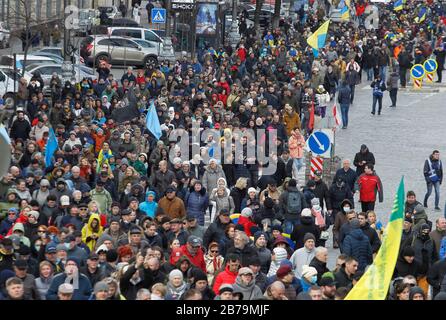 Foule de personnes avec drapeaux et bannières au cours de la marche.Des Milliers de militaires et de volontaires ukrainiens ont participé à la marche des patriotes marquant la Journée des volontaires en l'honneur des soldats qui ont rejoint l'armée ukrainienne lors d'un conflit militaire dans l'est de l'Ukraine. Banque D'Images