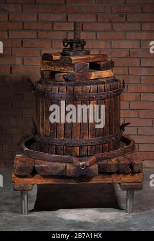 Vieux tonneau en bois de machine à vendanger sur un fond de mur de brique. Production de vin écologique maison à la ferme. Banque D'Images