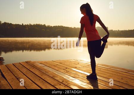 Réchauffer les jambes s'étendant dans le sport. Banque D'Images