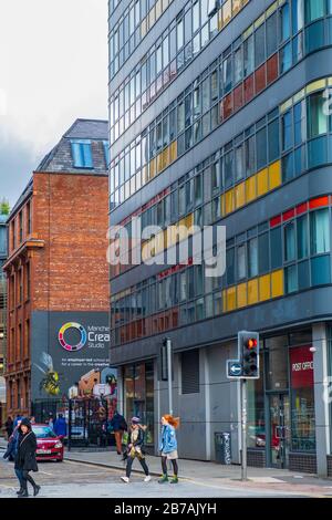 Manchester, Royaume-Uni - 1 mars 2020: Les gens marchent devant les feux de circulation dans la région d'Ancoats de Manchester Banque D'Images