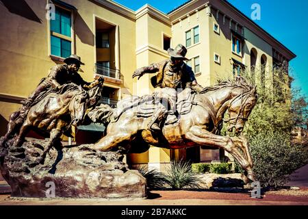 Une sculpture commémorative en bronze équine, « Passing the Legacy » de deux cavaliers de Hashlatter Pony Express qui distribuent le US Mail à Scottsdale, AZ, États-Unis Banque D'Images