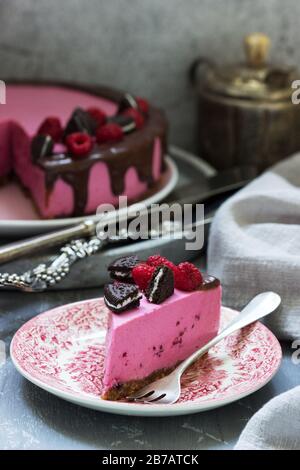 Gâteau à la mousse de curricassis décoré de petits gâteaux et de framboises. Banque D'Images