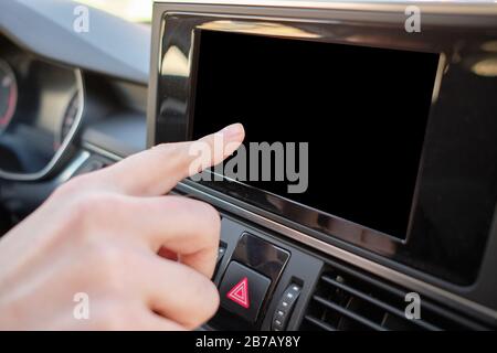 Un homme dans une voiture moderne. Appuyez à la main sur l'écran du moniteur. Gros plan. Banque D'Images