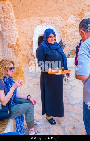 Berbères avec touristes dans une maison troglodyte. Matmata. Tunisie, Afrique. Banque D'Images
