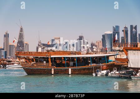 Des bateaux à hocher garés au port de Dhow avec le centre-ville de la financwial visible derrière, un matin d'été à Doha, Qatar Banque D'Images