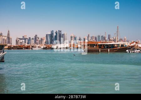Des bateaux à hocher garés au port de Dhow avec le centre-ville de la financwial visible derrière, un matin d'été à Doha, Qatar Banque D'Images
