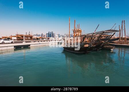 Des bateaux à hocher garés au port de Dhow avec le centre-ville de la financwial visible derrière, un matin d'été à Doha, Qatar Banque D'Images