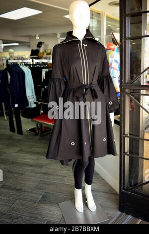 Un mannequin sans visage modélise un trench noir stylisé à l'entrée de la boutique Dames Fashion dans la vieille ville de Scottsdale, AZ, États-Unis Banque D'Images