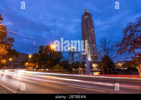 Messeturm à Francfort pendant l'heure de bleu avec des feux de rue et des sentiers légers Banque D'Images