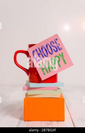 Le signe de texte indiquant choisir heureux. Photo d'entreprise présentant la capacité de créer le bonheur réel et durable pour vous-même tasse de café blanc collant note pile Banque D'Images