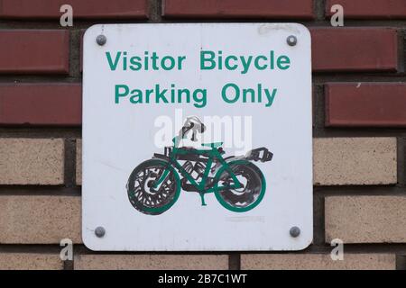 Vue du panneau sur le mur de briques 'Visitor Bicycle parking seulement' dans le centre-ville de Vancouver Banque D'Images