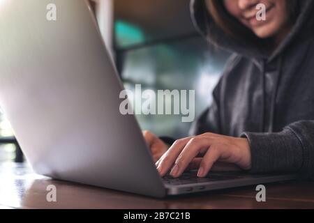 Gros plan image d'une femme travaillant et tapant sur le clavier de l'ordinateur portable sur la table Banque D'Images