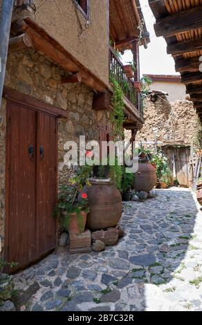 La vue de la rue pavée de la sade en pierre étroite de l'ancienne Kakopetria bordée de fleurs dans les pots. District de Nicosie. Chypre Banque D'Images