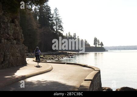 Vancouver, Canada - 21 février 2020 : une femme est sur le sentier côtier près de la troisième plage du parc Stanley pendant la belle journée ensoleillée Banque D'Images