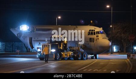 Frederick, États-Unis. 15 mars 2020. L'équipage au sol de Legacy Aerospace and Defense manoeuvrer un avion militaire retraité de 1974 de l'armée de l'air américaine Lockheed C-130 J Hercules de l'aéroport municipal de Frederick à fort Detrick, une station de commandement médical de l'armée américaine, à Frederick, Maryland, le samedi 14 mars 2020. Les ailes, les moteurs et la queue de l'aéronef déclassés ont été démontés après l'atterrissage de l'aéronef en septembre 2019 et ils seront réassemblés puis équipés comme banc d'essai pour les dispositifs, les situations ou les procédures. Photo de David Tulis/UPI crédit: UPI/Alay Live News Banque D'Images