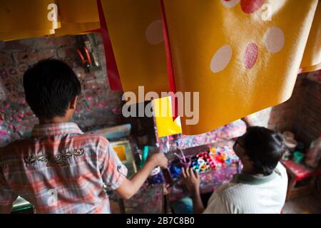 Proshanto Kumar Das, fils de Raj Kumar Das, plus connu sous le nom de RK Das, l'un des artistes de pousse-pousse de première génération au Bangladesh, est engagé dans la peinture d'un art en pousse-pousse alors que son on Joy l'aide dans son studio de la capitale Dhaka, le 3 mai 2012. L'art du pousse-pousse est une forme d'art pop qui décrit notre culture urbaine et notre folklore du Bangladesh. Les pousse-pousse ont été introduits pour la première fois au Bangladesh dans les années 1930 à partir du Japon, où les véhicules à trois roues étaient connus sous le nom de 'nintaku'. L'idée de décorer les contraditions de jambes a pris le départ au Bangladesh les années 1950 avec la tradition suivant le simple mais colorf Banque D'Images