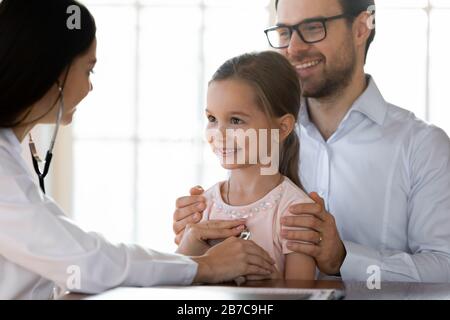 Le travailleur médical écoute les poumons battement de cœur de la petite fille patient. Banque D'Images