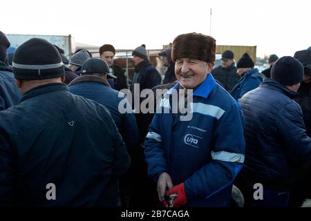 Portrait d'un homme portant un chapeau de fourrure sur le marché du bétail du matin dans un village près de Boukhara, Ouzbékistan Banque D'Images