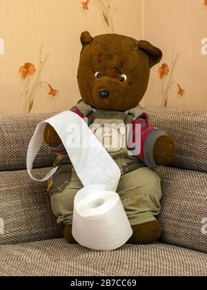 un ours triste et triste en peluche très vieux avec du papier toilette Banque D'Images