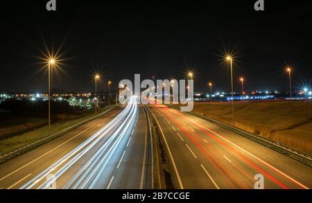 Feux de route sur l'A12 aux Pays-Bas la nuit. Sortie 10 avec le nom de lieu 'Mordrecht' après 1700 mètres est écrit sur un panneau de circulation. Banque D'Images