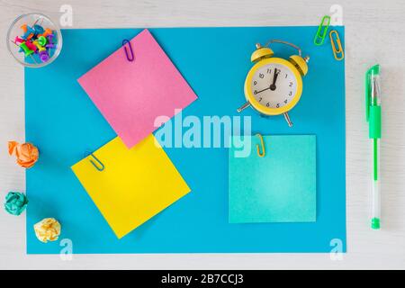 Cartes colorées avec espace pour une inscription, horloge montrant cinq minutes à douze. bureau ou concept d'affaires. Banque D'Images