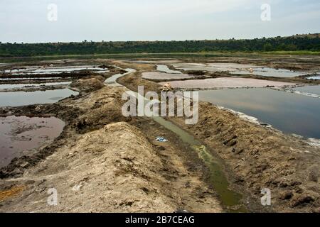 L'eau salée du cratère et les températures chaudes permettent la récolte de sels qui s'évaporent dans des bassins peu profonds construits dans le lac du cratère. Banque D'Images