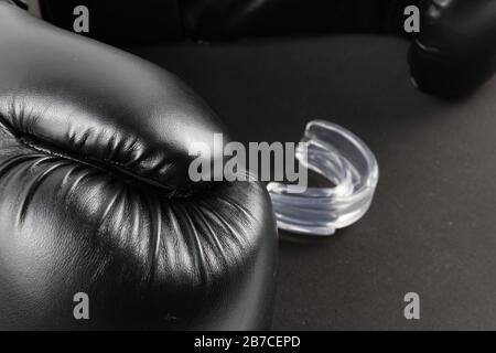 Gants de boxe et protège-bouche sur fond noir. Image du produit Banque D'Images