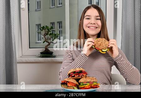 bonne fille avec des sandwichs végétaliens à la maison Banque D'Images