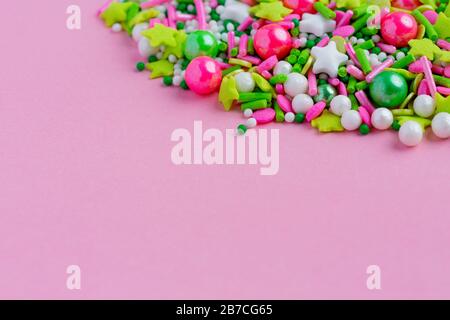 Pois saupoudrés de sucre multicolores, décoration pour gâteau et bekery sur fond rose. Pâques Banque D'Images