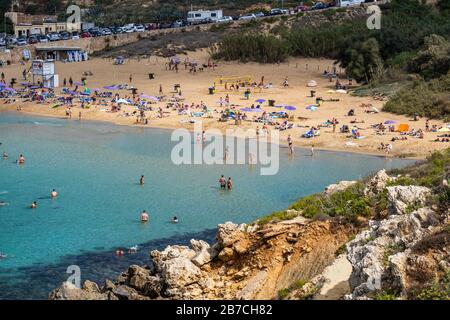 Les gens en vacances se détendre à la station balnéaire de Golden Bay sur l'île de Malte en mer Méditerranée Banque D'Images