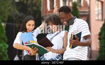 Les étudiants multiculturels surplaisantés qui ont fait le bilan des résultats de l'examen et qui ont fait le bilan de leur réussite Banque D'Images