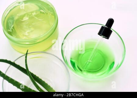 Gel d'aloès, feuilles d'aloe vera et sérum vert à partir d'ingrédients naturels sur fond blanc. Faire des cosmétiques à la maison. Banque D'Images