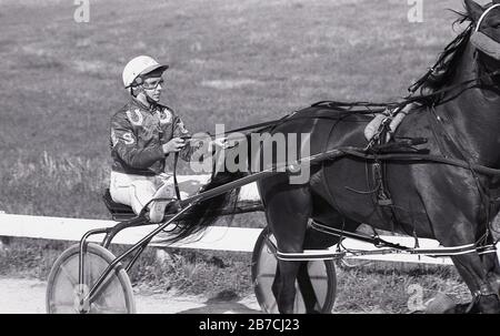 1980, historique, course de harnais ou parfois connu sous le nom de poney et de course de piège, l'image montre une femelle pilote ou pilote qui monte un 'sulky', une petite voiturette à deux roues attachée à un cheval, Angleterre, Royaume-Uni. Banque D'Images