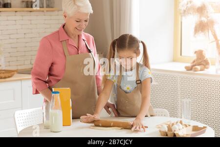 Adorable enfant apprenant comment cuire de sa granny à la maison Banque D'Images