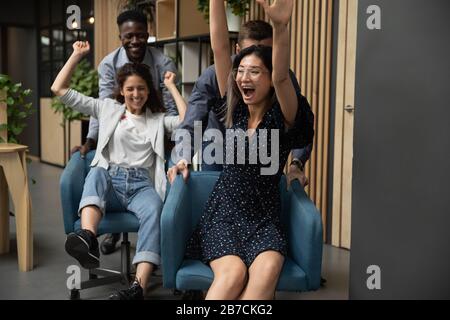 Les femmes d'affaires excitées qui s'amusent sur les chaises, les collègues sont divers Banque D'Images
