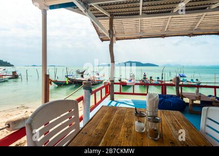 Ko Samui, Thaïlande - 2 janvier 2020: Bateaux de pêche thaïlandais authentiques vus par la terrasse de boulangerie française à Ko Samui un jour lumineux Banque D'Images