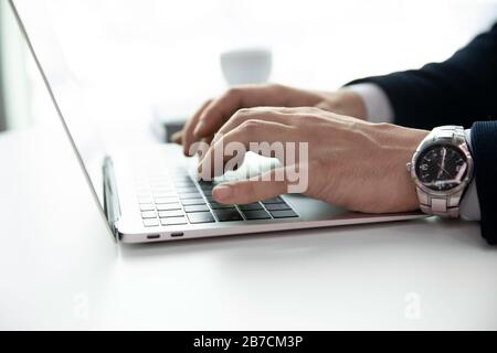 Homme d'affaires réussi à envoyer des SMS sur un ordinateur portable moderne Banque D'Images