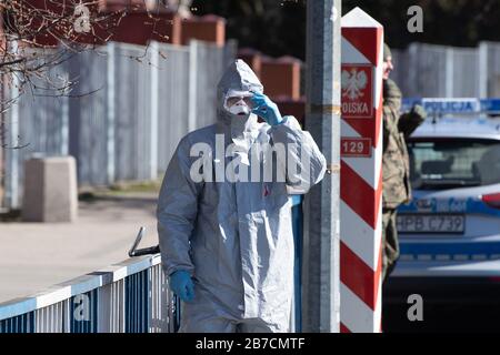 15 mars 2020, Saxe, Görlitz: Un homme en costume de protection se tient devant un poste frontalier sur le pont de l'amitié à la frontière polonaise à l'extérieur de Zgorzelec à l'est de la rivière Neisse. La Pologne a fermé ses frontières avec l'Allemagne et d'autres pays voisins de l'UE aux étrangers pendant la nuit du dimanche au dimanche en raison de la crise du coronavirus. Photo: Sebastian Kahnert/dpa-Zentralbild/dpa Banque D'Images