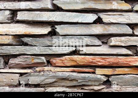 Détaillez une partie de l'ancien mur de retenue en pierre à partir de morceaux de grès plat. Banque D'Images