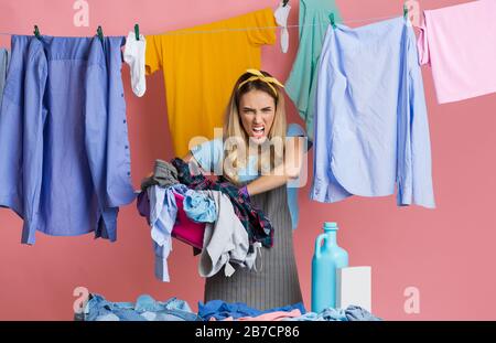 Femme de ménage méchante avec linge sale, poudre et après-shampooing Banque D'Images