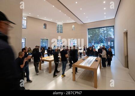 Les clients parcourent les produits Apple dans le magasin Apple Store situé sur l'avenue des champs-Elysées à Paris, en France, en Europe Banque D'Images