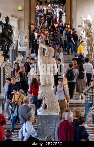 Vue arrière de la sculpture en marbre de l'esclave de la Renaissance italienne Michel-Ange dans une salle bondée au Musée du Louvre à Paris, France, Europe Banque D'Images
