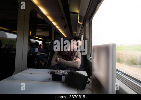 Jeune femme dormant pendant un voyage en TGV, France, Europe Banque D'Images