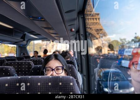 Heureuse jeune femme en bus à Paris avec la Tour Eiffel en arrière-plan, Paris, France, Europe Banque D'Images