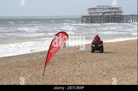 Brighton UK 15 mars 2020 - un panneau danger bord de mer se plie au vent lors d'une journée de brumerie le long de la plage de Brighton, mais le climat plus réglé est prévu pour la semaine prochaine en Grande-Bretagne : crédit Simon Dack / Alay Live News Banque D'Images