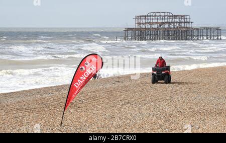 Brighton UK 15 mars 2020 - un panneau danger bord de mer se plie au vent lors d'une journée de brumerie le long de la plage de Brighton, mais le climat plus réglé est prévu pour la semaine prochaine en Grande-Bretagne : crédit Simon Dack / Alay Live News Banque D'Images